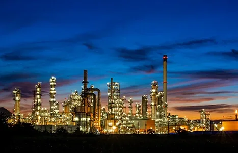 Oil refinery lit up at dusk
