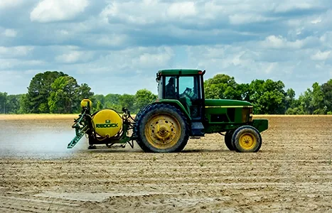 Tractor spraying agrochemicals on farmland