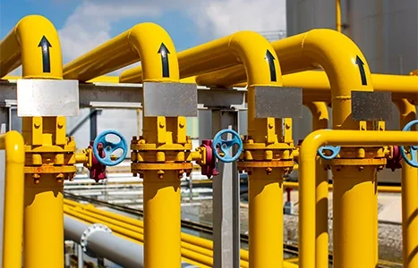 Yellow gas pipelines and valves at an oil and gas facility