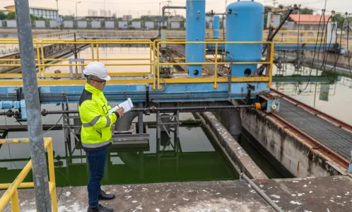 Engineer inspecting an industrial water treatment basin